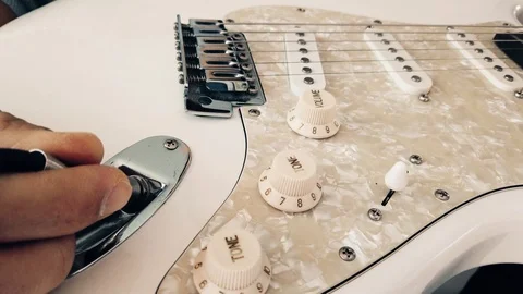 Close up of guitarist's hand plugging audio cable in electric guitar Stock Footage 102374847