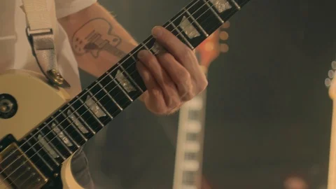 Close-up of guitarist's hands playing on white electric guitar on stage Stock Footage 121450528