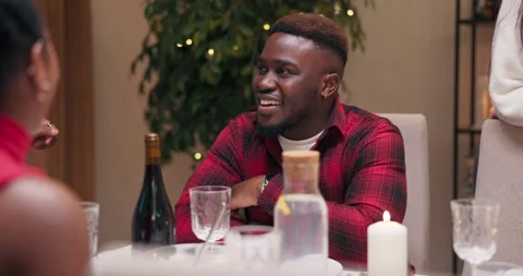 Close-up of guy of African appearance sitting at festive table, talking with 스톡 동영상 218262347