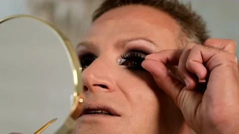 Close up of Guy applying the false eyelashes  looking at the mirror. Stock Footage 161834137
