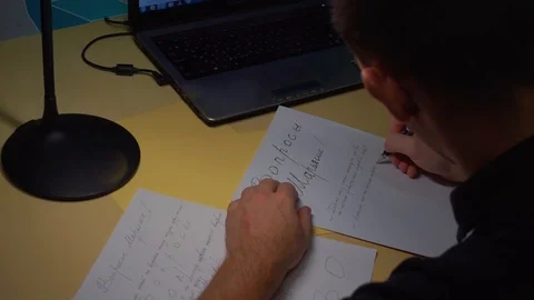 Close-up. The guy carefully displays letters on a piece of paper in a letter Stock Footage 121855154