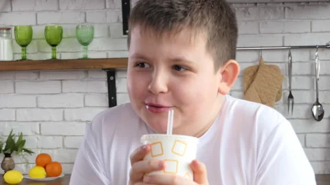 Close-up of a guy drinking from a paper cup through a straw. The guy drinks soda Stock Footage 232889777