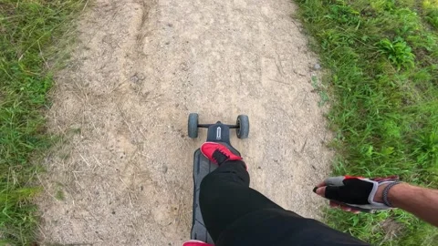 Close up A guy on an electric longboard rides through the park Stock Footage 260867192