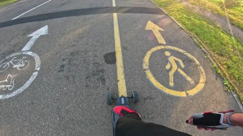 Close up A guy on an electric longboard rides through the park Stock Footage 260867212