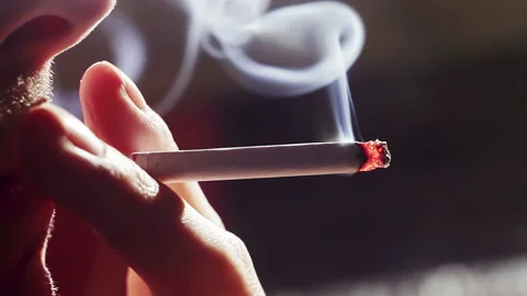 Close-up, guy holds cigarette between two fingers, and smokes smoking cigar.. Stock Footage 224298821