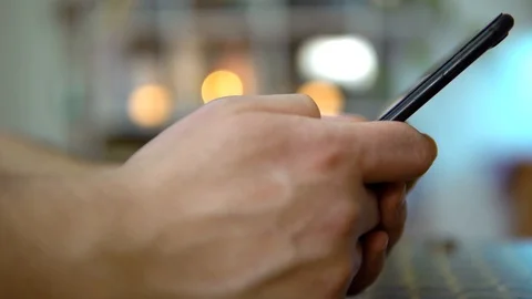 Close-up, the guy holds the phone in both hands and scrolls the news feed.. On a Video stock 127117938