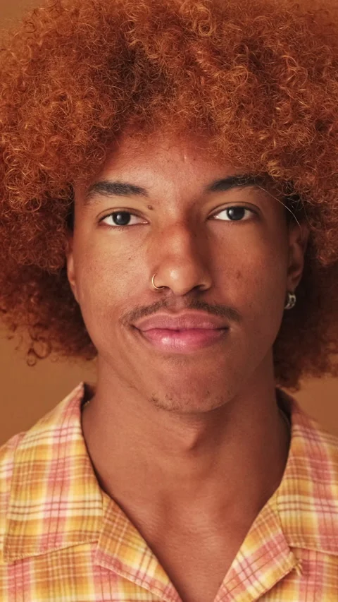 Close up, guy looking at the camera with smile isolated on brown background in Video stock 254914191