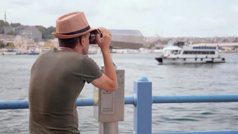 Close-up of guy looking through tourist binoculars on seashore. Video stock 253300153