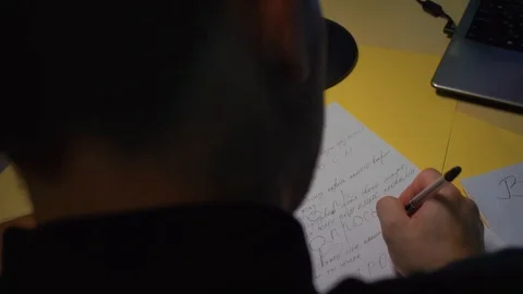 Close-up. The guy makes notes crazy, pen on paper, sitting at the table Stock Footage 121680422