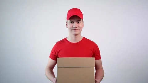 Close-up of a guy with a parcel in his hands showing a thumbs up gesture. Stockbeeldmateriaal 132851528