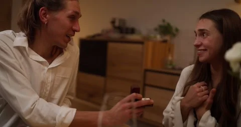 Close-up of a guy proposing to marry his girlfriend during a romantic dinner at Video stock 303833431