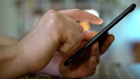 Close-up, the guy scrolling his finger on the screen of the phone. On a blurry Stock Footage 127350049