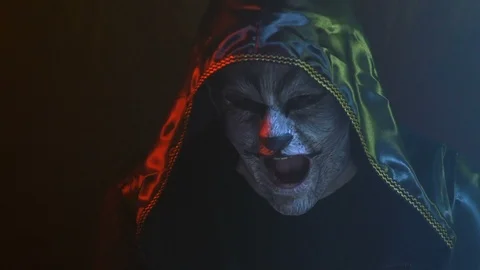 Close-up, Guy with Wolf Wolf on Face in Black Hood Imitates Animal Roar in Smoky Stock Footage 88451478
