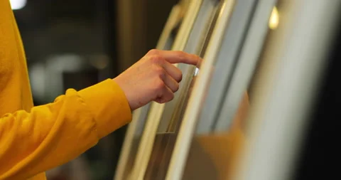Close up of a guy's hand in yellow clothes enjoys the touch screen of a bank Stock Footage 133422229