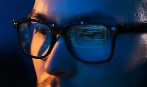 Close up of hacker in glasses looking at screen 写真素材