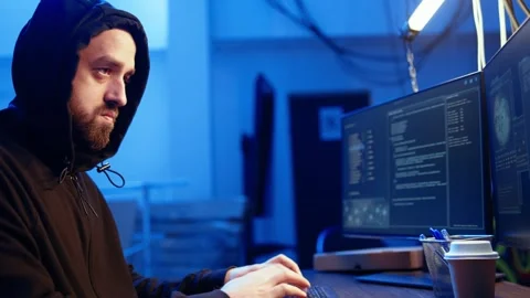 Close up of hacker in graffiti painted hideout focused on developing spyware Video stock 319522874