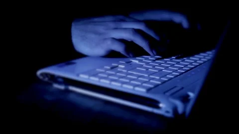 Close up of hacker hands typing on laptop in dark room Video stock 334873721