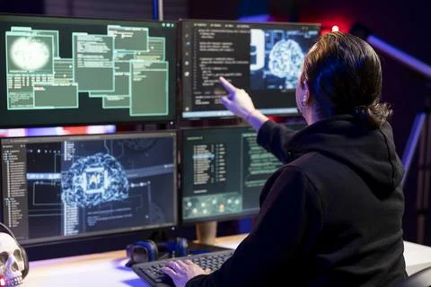 Close up of hacker in secret lair using AI to break into computer systems 库存照片