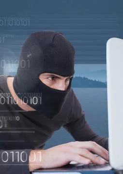 Close up of hacker working on laptop in front of blue background 库存照片
