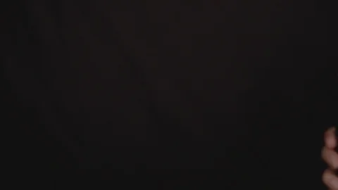 Close up hads clinking glasses with beer bottles against dark background. Slow Vídeo Stock 116039592