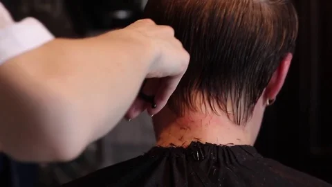 Close up of a hairdresser cutting hair. Hands of professional hair stylist Stock Footage
