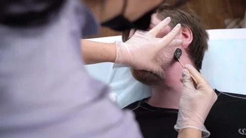 Close up hairy face man using wax epilation at beauty saloon. Stock Footage 149360614