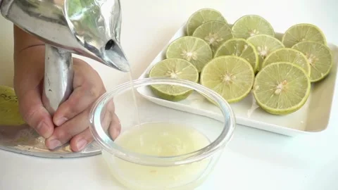 Close up of half and whole fresh lime juicy. hand squeezing lime juice from a Stock-Footage 336588525