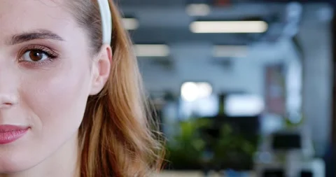 Close up of half of beautiful red-haired female face in coworking space Stock Footage 180054355