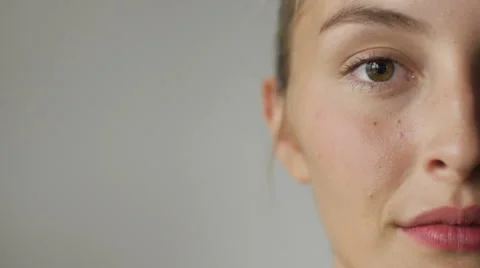 Close up half face of an attractive young woman against a white background Видео 66690930