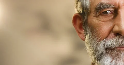 Close up of half face of gray-haired old Caucasian man with beard smiling Video stock 135659082