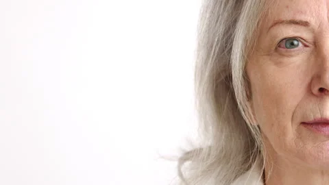 Close-up Half Face of a Pensive Senior Woman with a White Background Stock Footage 264585465