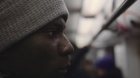 Close-up half-face shot of african young man in subway Stock Footage 102437637