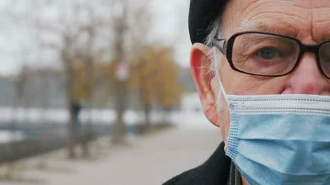 Close up of half face of upset Caucasian elderly senior in medical mask looking Video stock 143726416