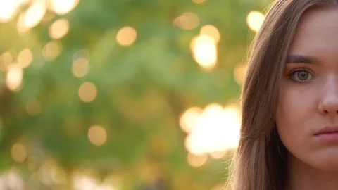 Close up of the half female face with long brown hair looking in the camera and  Stock Footage 120598666