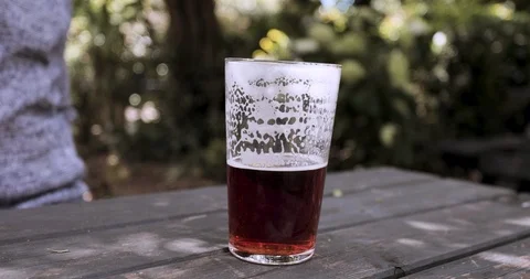 Close up half full pint real ale beer in pub garden Stock Footage 116042158