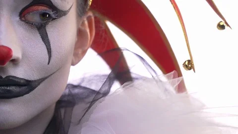 Close up of the half of jesters face, black and white makeup, looking around Stock Footage 104544995