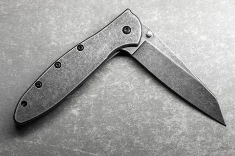 Close-up of a half opened folding pocket knife with a stonewashed blade Stock Photos