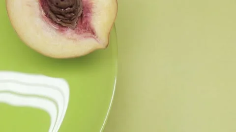 Close-up half of peach fruit with stone rotates on a green-yellow background Stock-Footage 139922649