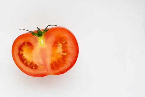 Close-up half of red tomato isolated on white background, copy space. The con Stock Photos