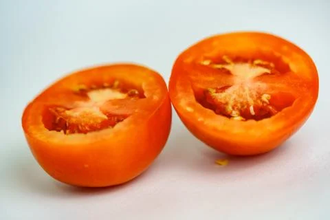 A close up of a half red tomato in a white background Stock Photos