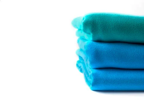 Close up half stack towels green and blue on white background with copy space Stock Photos