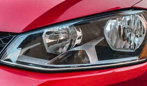 Close-up of halogen car headlights on a red car. Car details Stock Photos