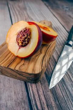 Close-up on a halved nectarine with a knife Stock Photos