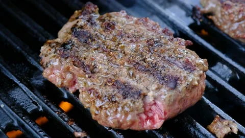 Close up of a hamburger cooking on a grill Stock Footage 138452960