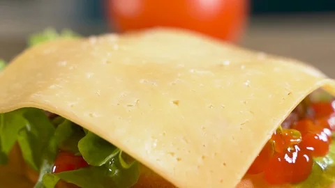 Close up: Hamburger roll falls on the cutlet, cheese and onions. Slow motion Stock Footage 111342698