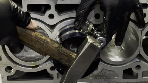 Close up of hammer tapping piston into silver car engine. Stock Footage 332065005
