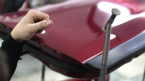 Close-up hammer, which knock on the red car to align dents without painting Stock Footage 151786967