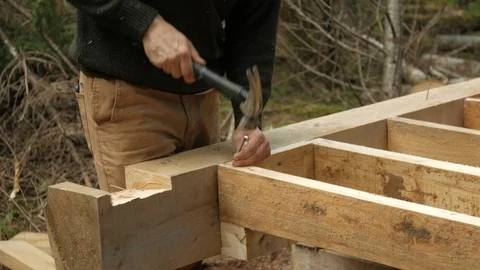 Close up Hammering Floor Joist on deck of cabin in forest, 4k Video stock 120314164