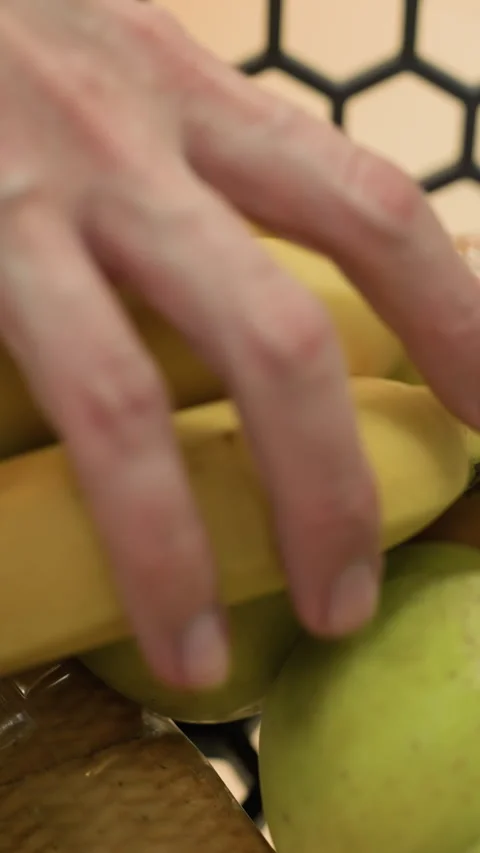 Close-Up of Hand Adding Bananas to Shopping Trolley with Biscuits, Juice, Bread Stock Footage 316500495