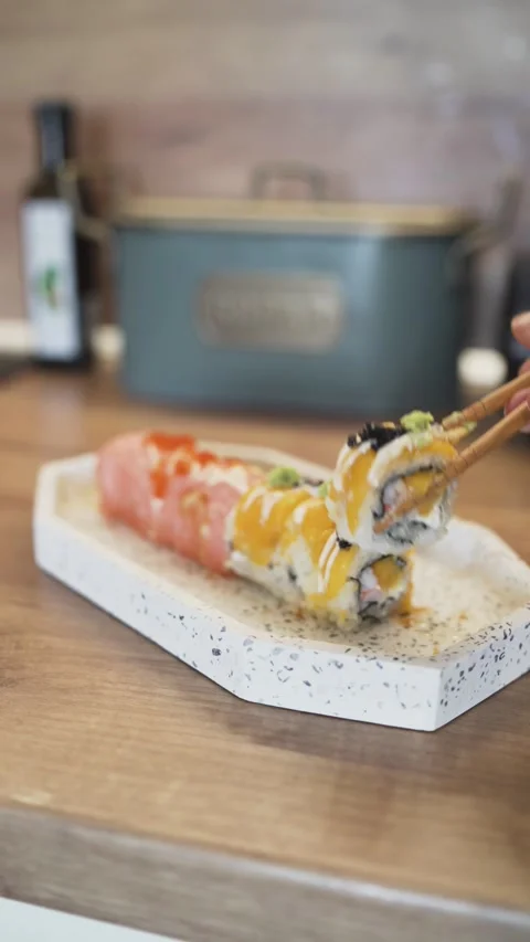 Close-Up of Hand Adding Final Ginger Garnish on Sushi Rolls in a Homemade Stock Footage 306650568